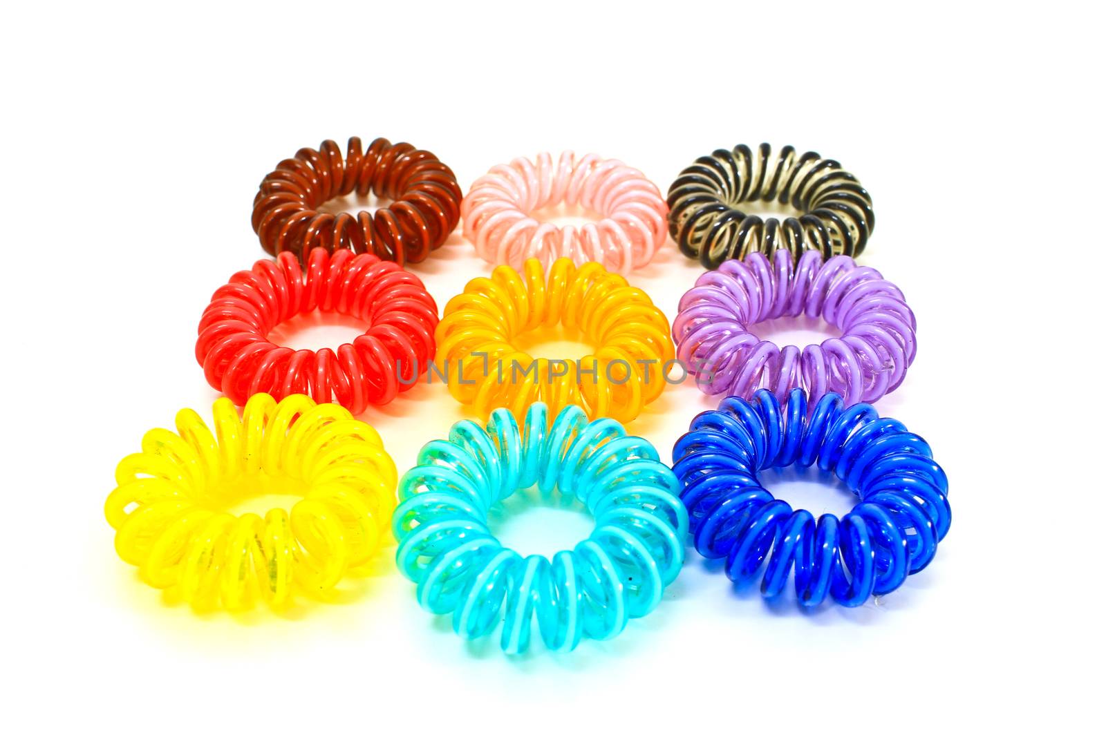 Spiral colorful elastic hair ties used on a white background.