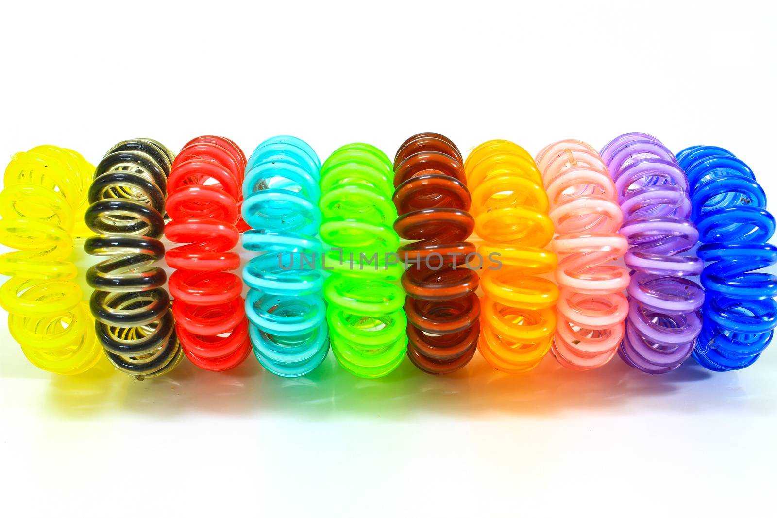 Spiral colorful elastic hair ties used on a white background.