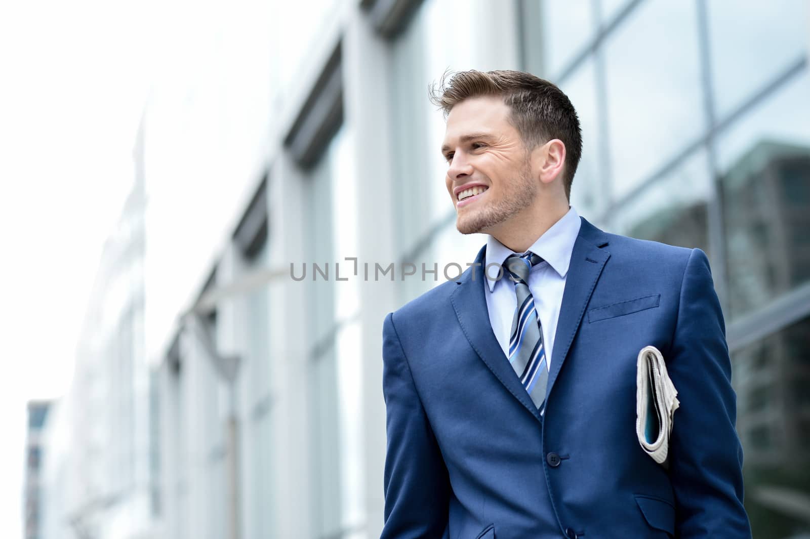 Young businessman holding a newspaper at outdoors