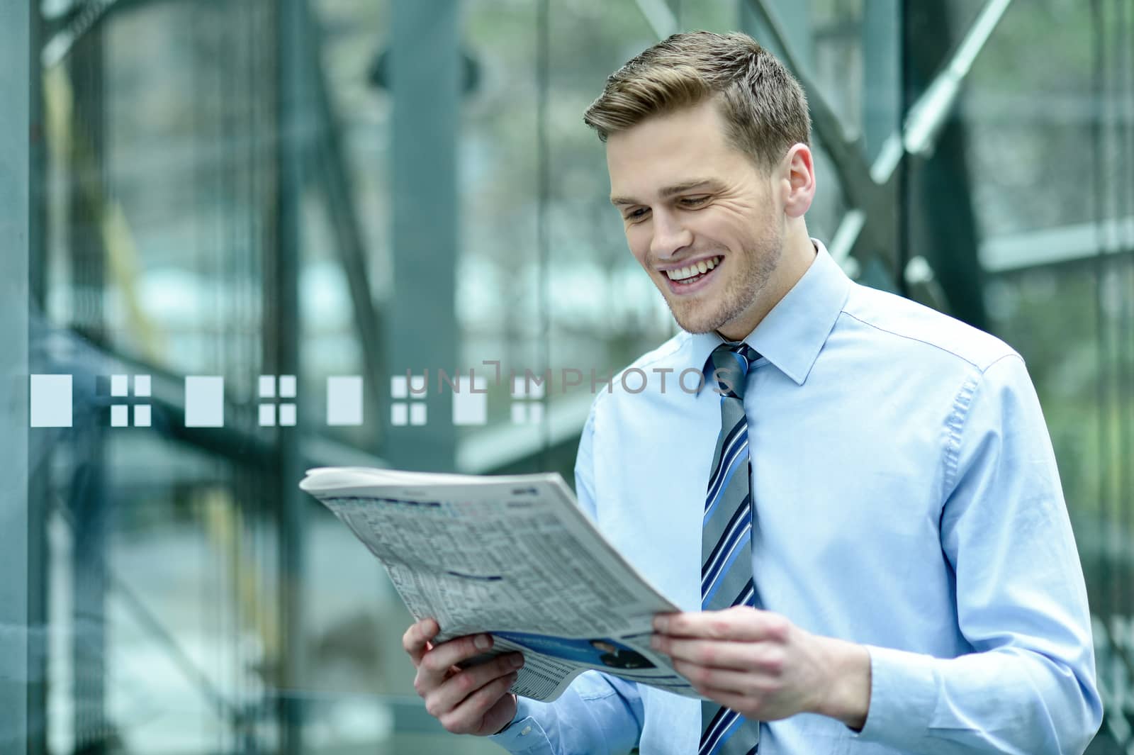 Young businessman reading newspaper at outdoors