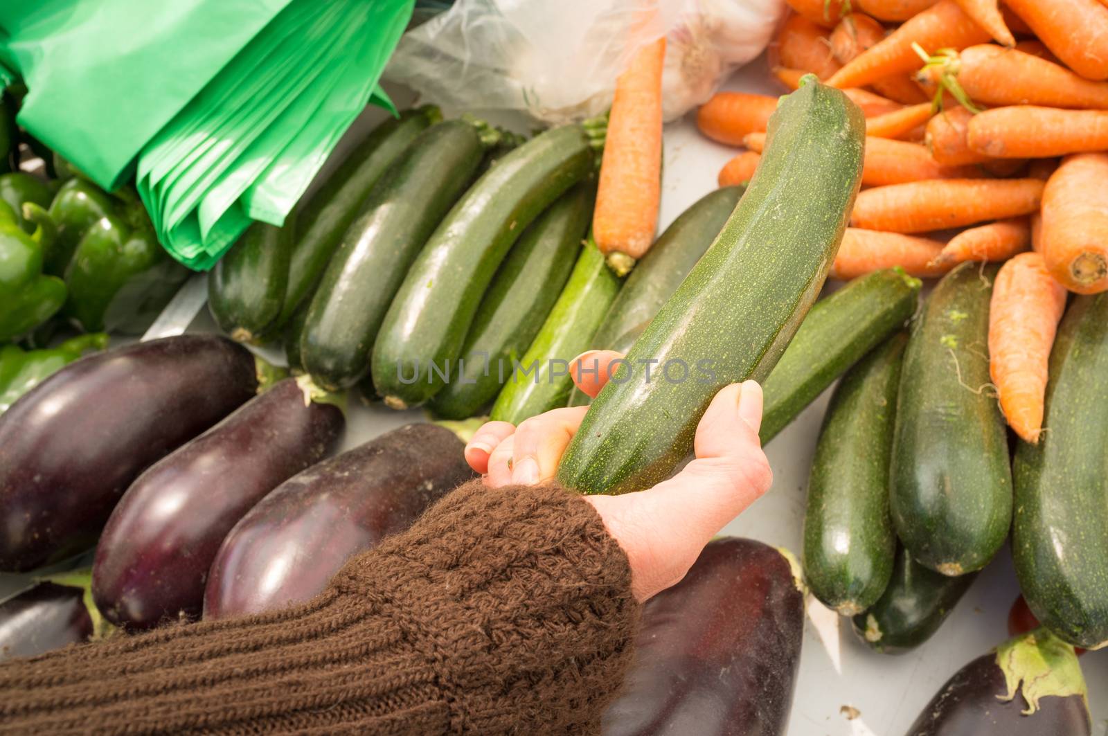 Female hands choosing vegetables on a street market stall