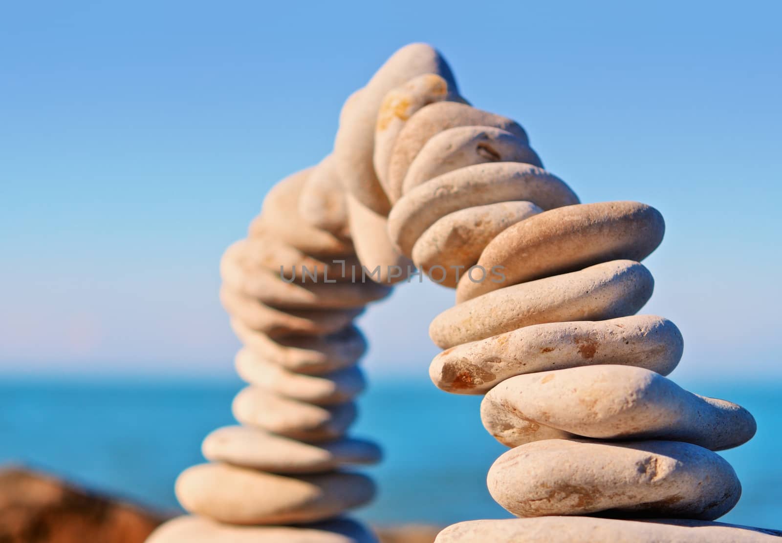 Arc of white pebbles in the balance on the seacoast