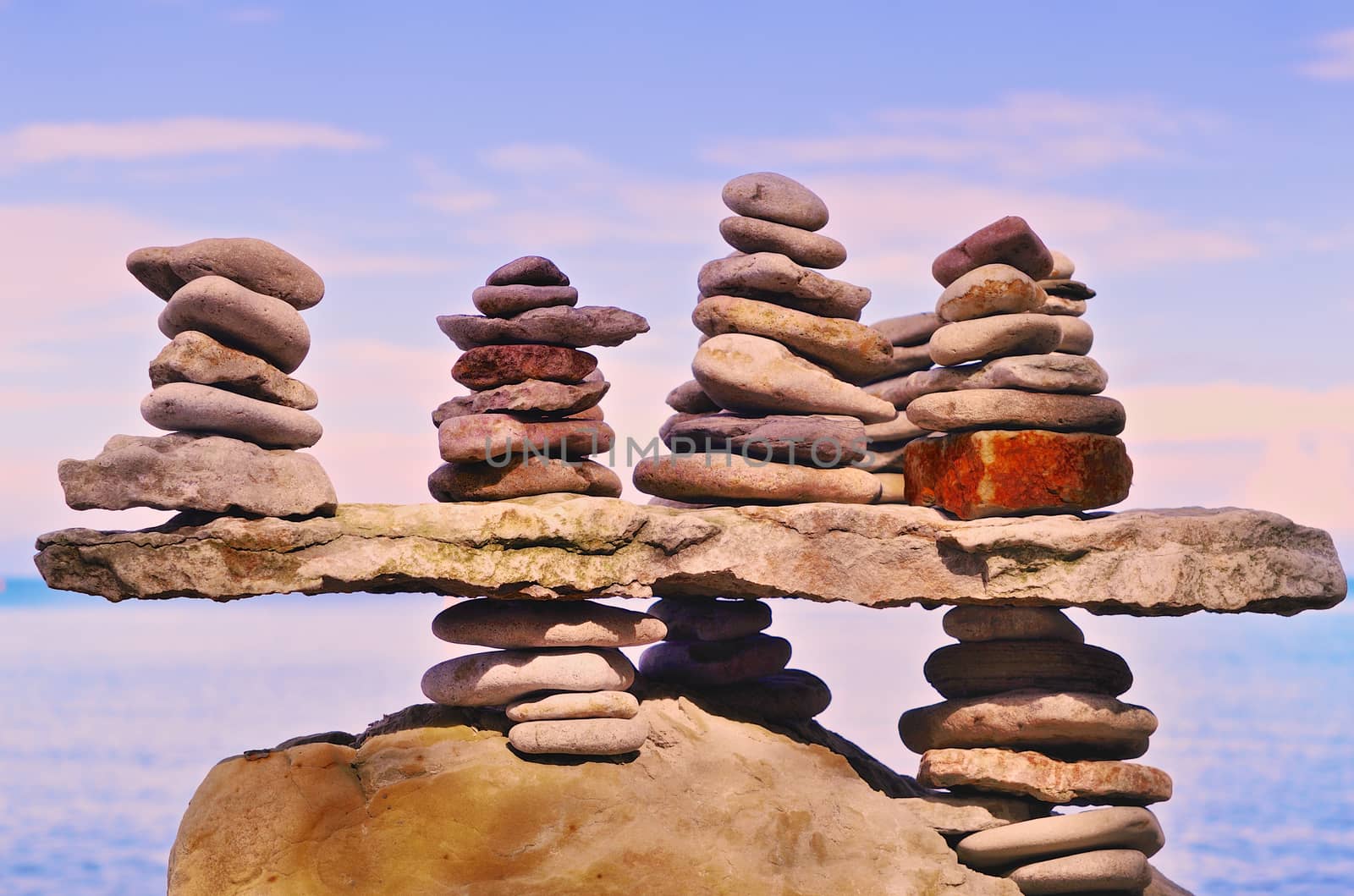 Balancing of several piles of pebbles on a boulder