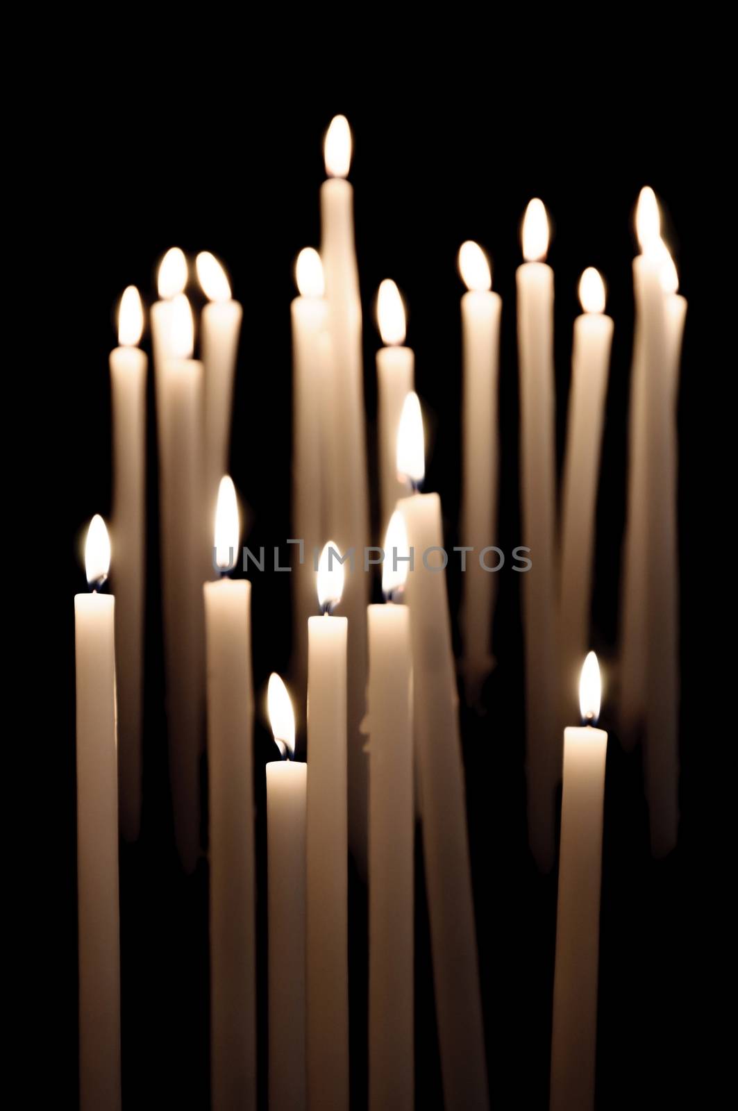 Candles burning in a church by dutourdumonde