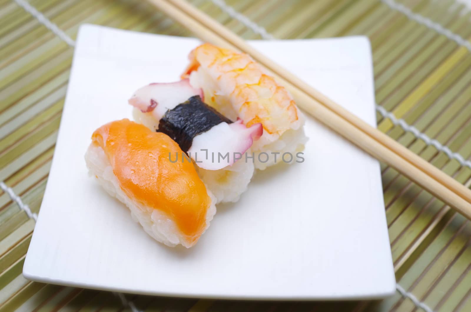 Sushi nigiri in with dish with bamboo sticks 