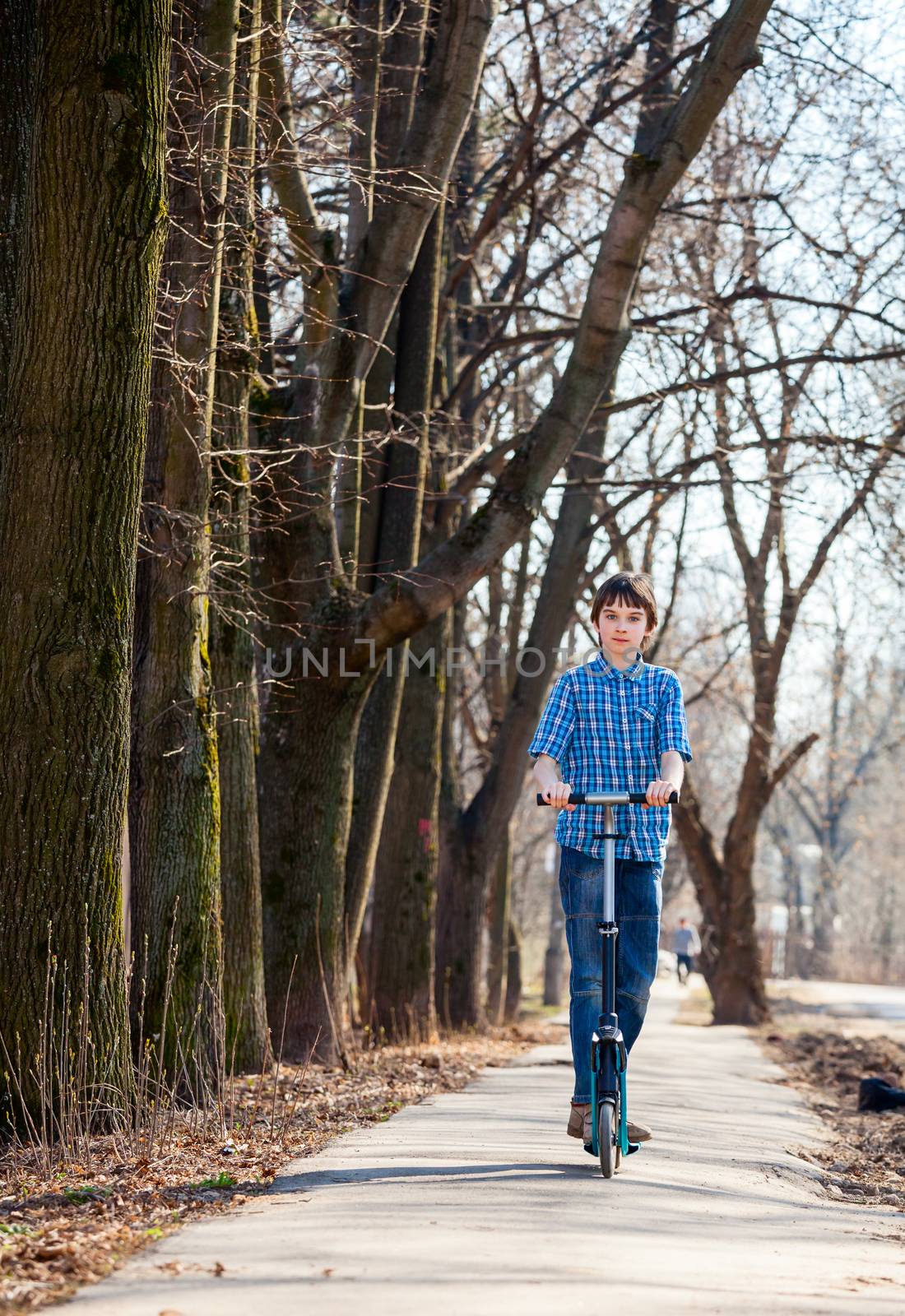 Kid riding his push scooter outdoors
