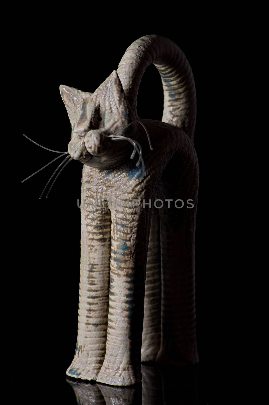 Cat figurine on black background by anderm