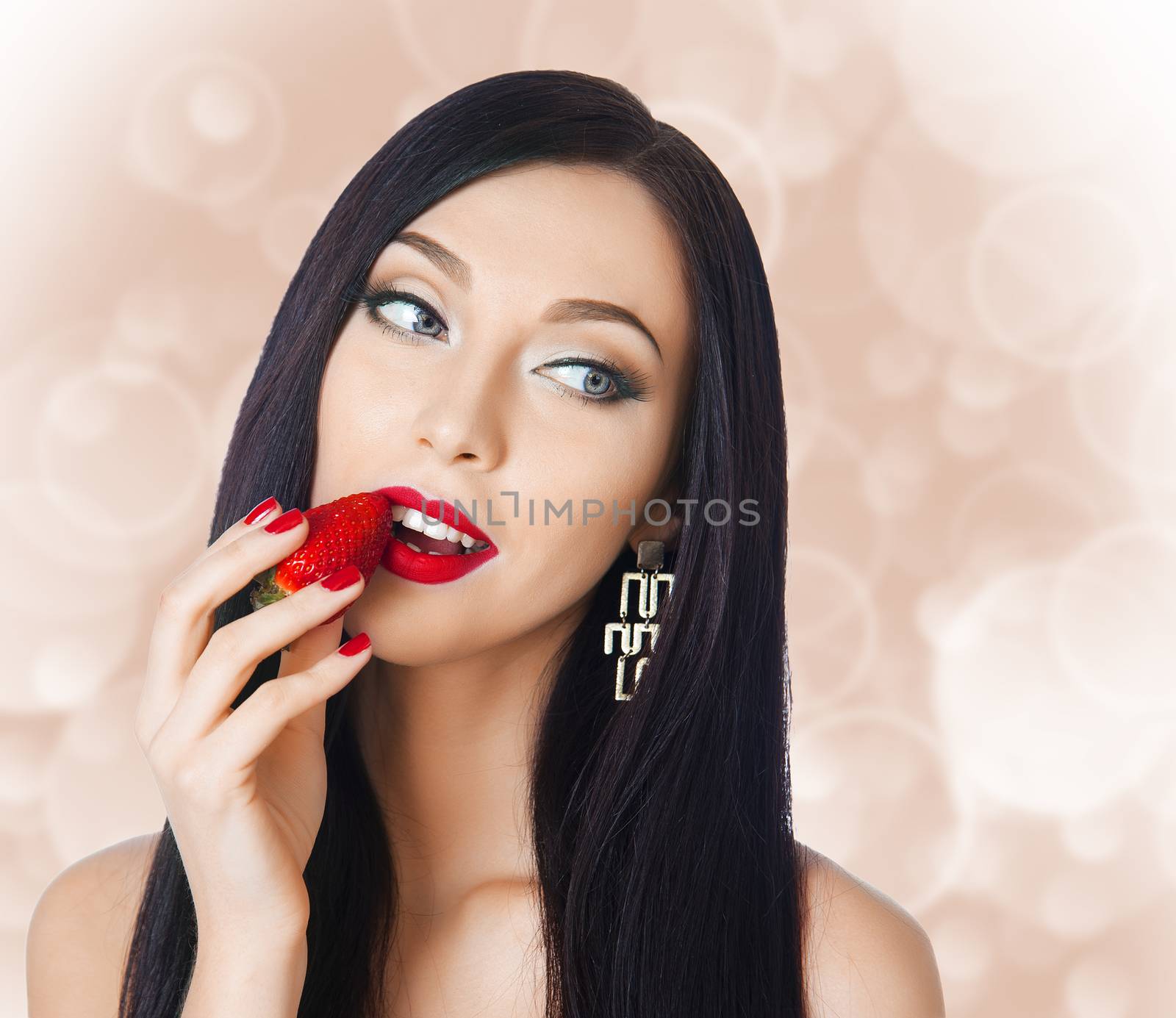 beautiful brunette with long eyelashes eating strawberries