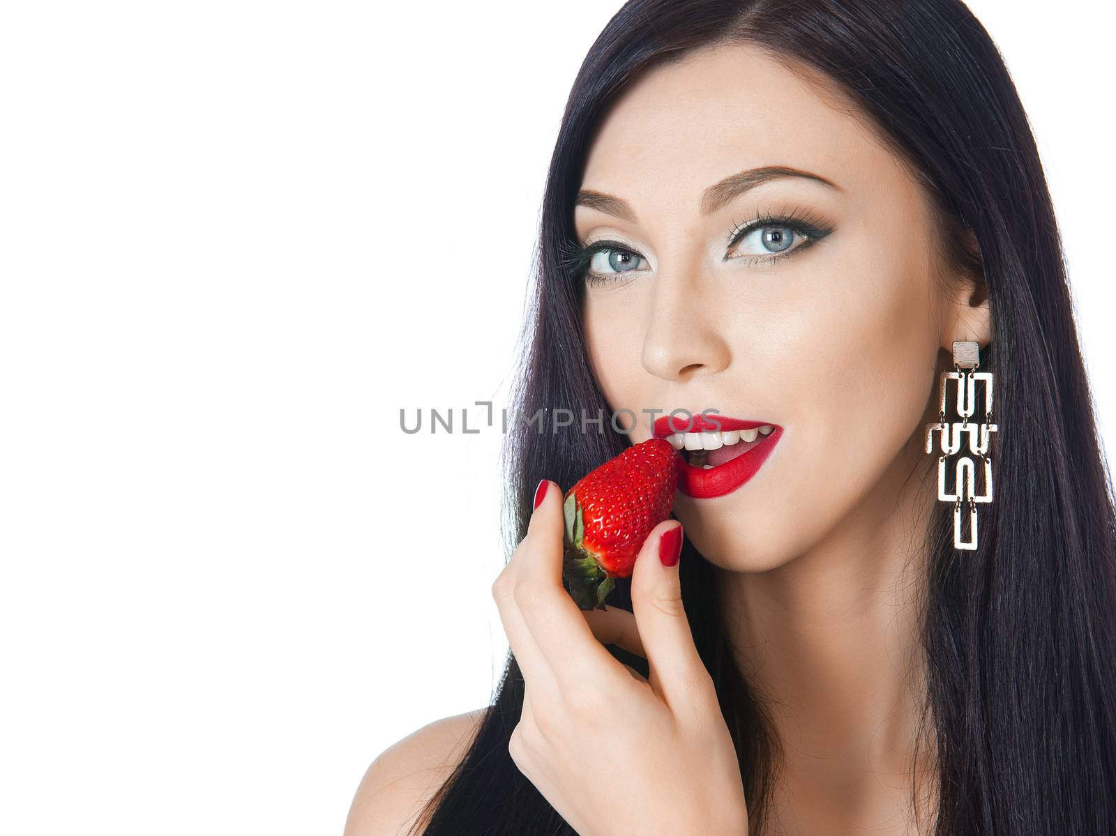 beautiful brunette with long eyelashes eating strawberries