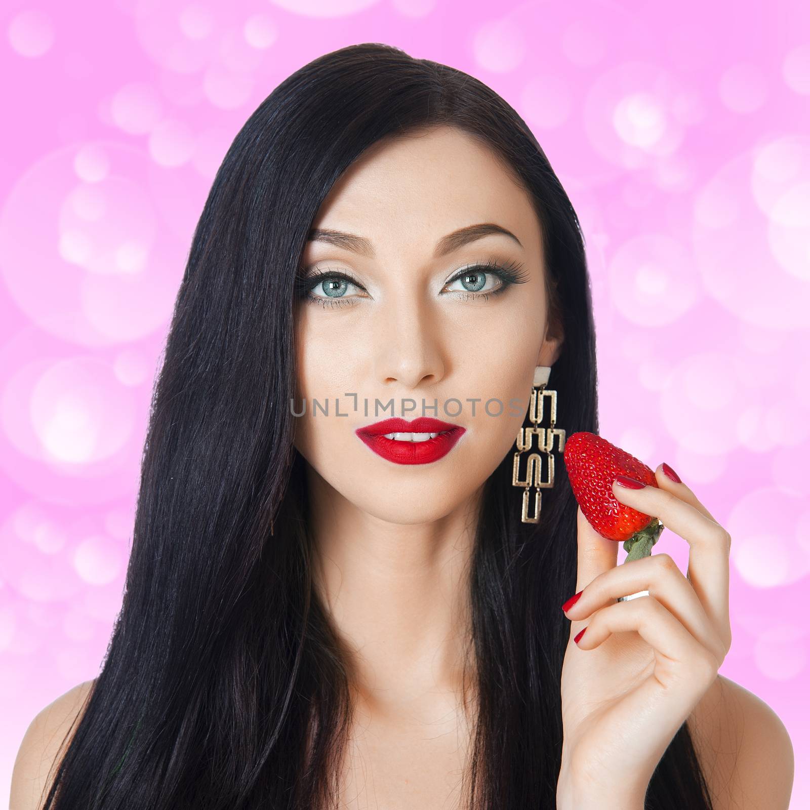 beautiful brunette with long eyelashes eating strawberries