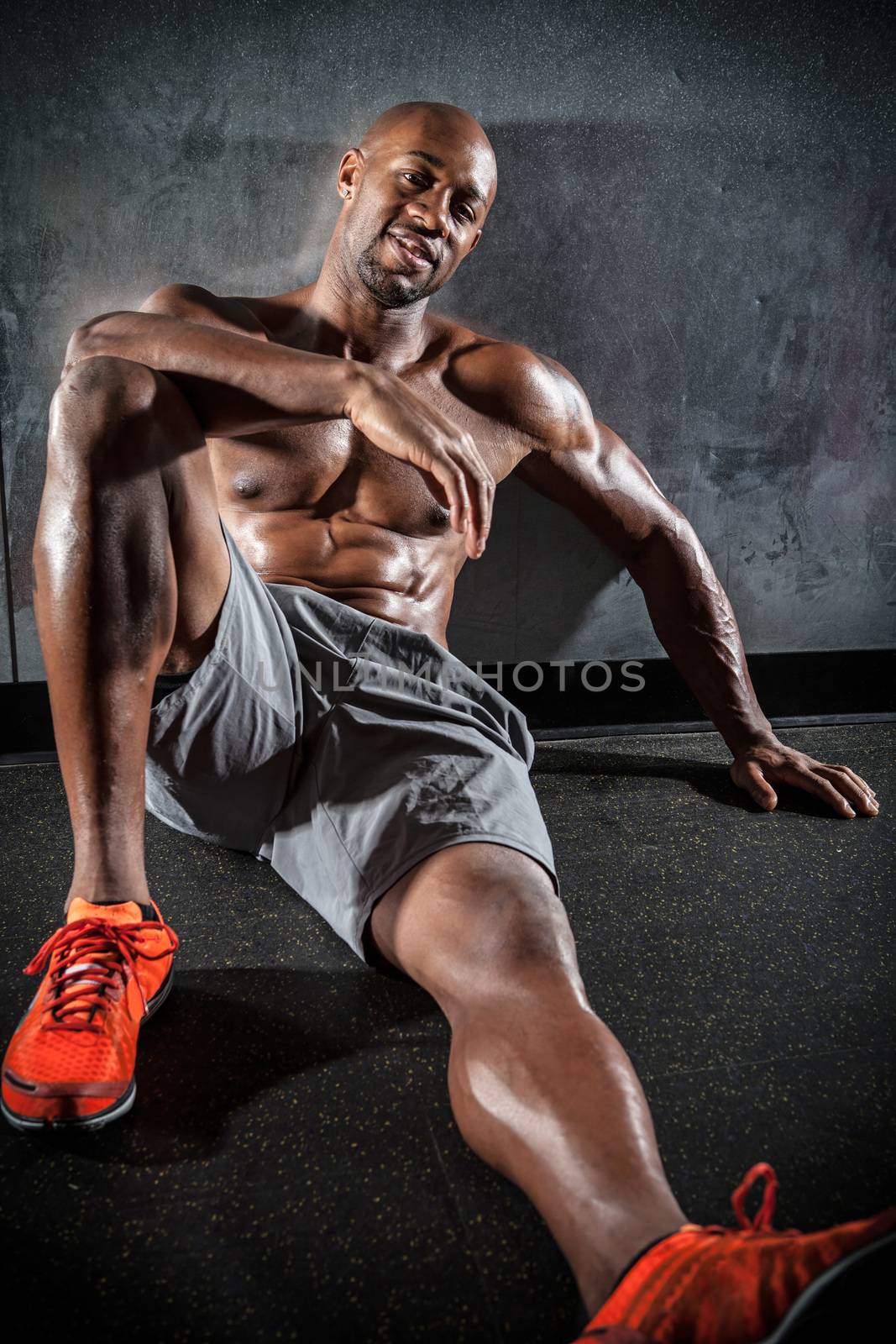 Portrait of a lean toned and ripped muscle fitness man under dramatic low key lighting.