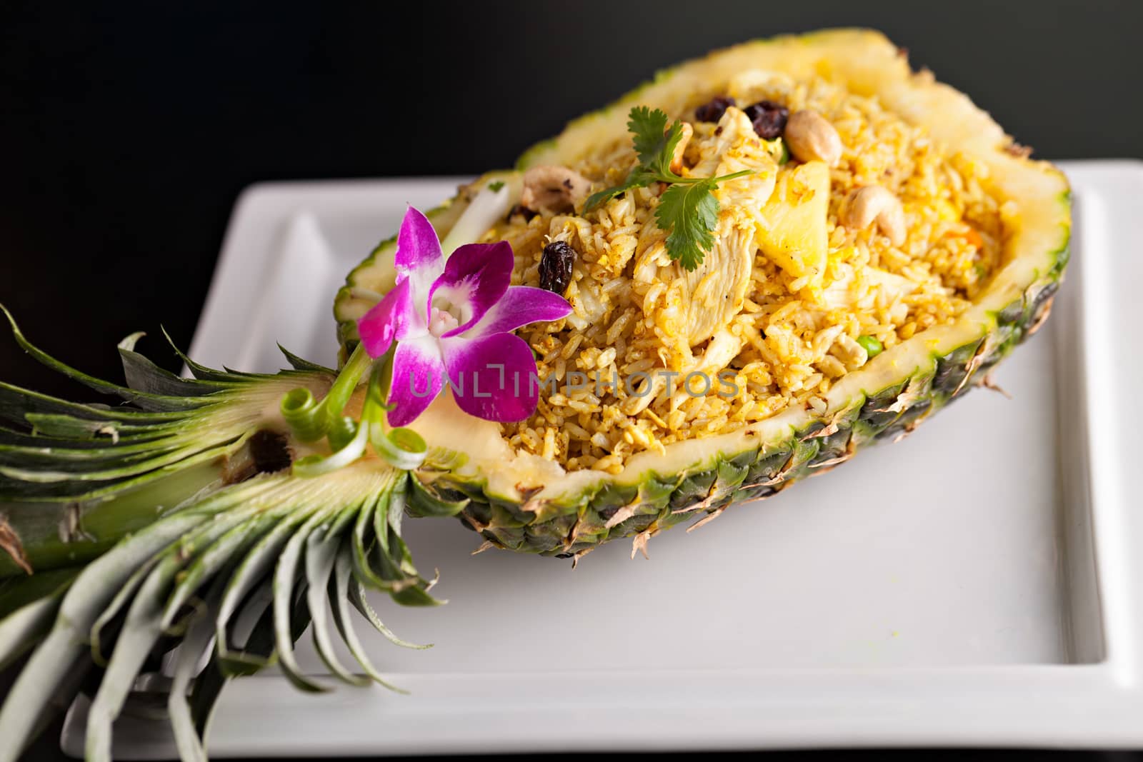 Freshly prepared pineapple fried rice served inside of a pineapple carved like a bowl.