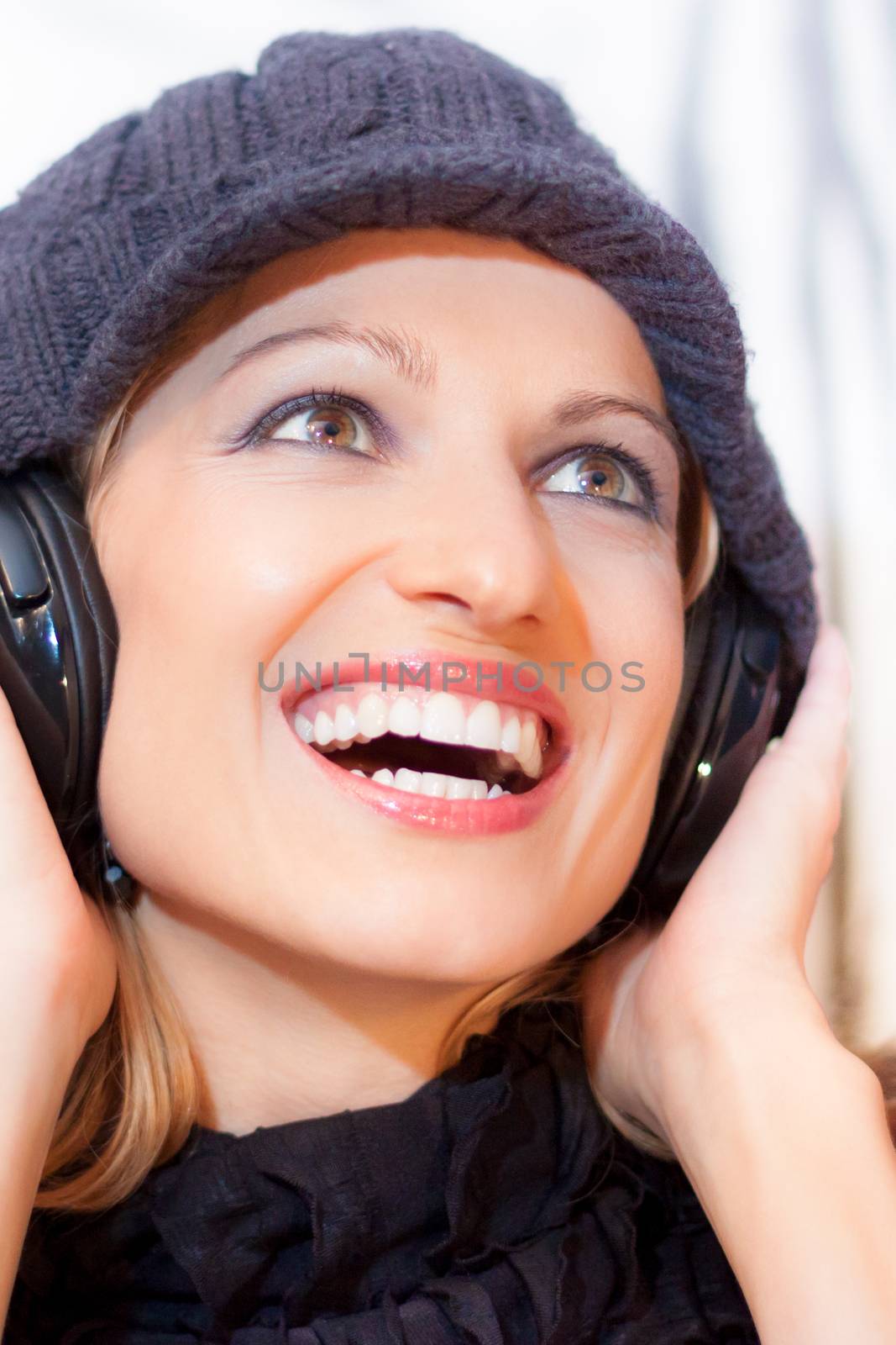 Blonde caucasian girl listening to the music with a pair of headphones