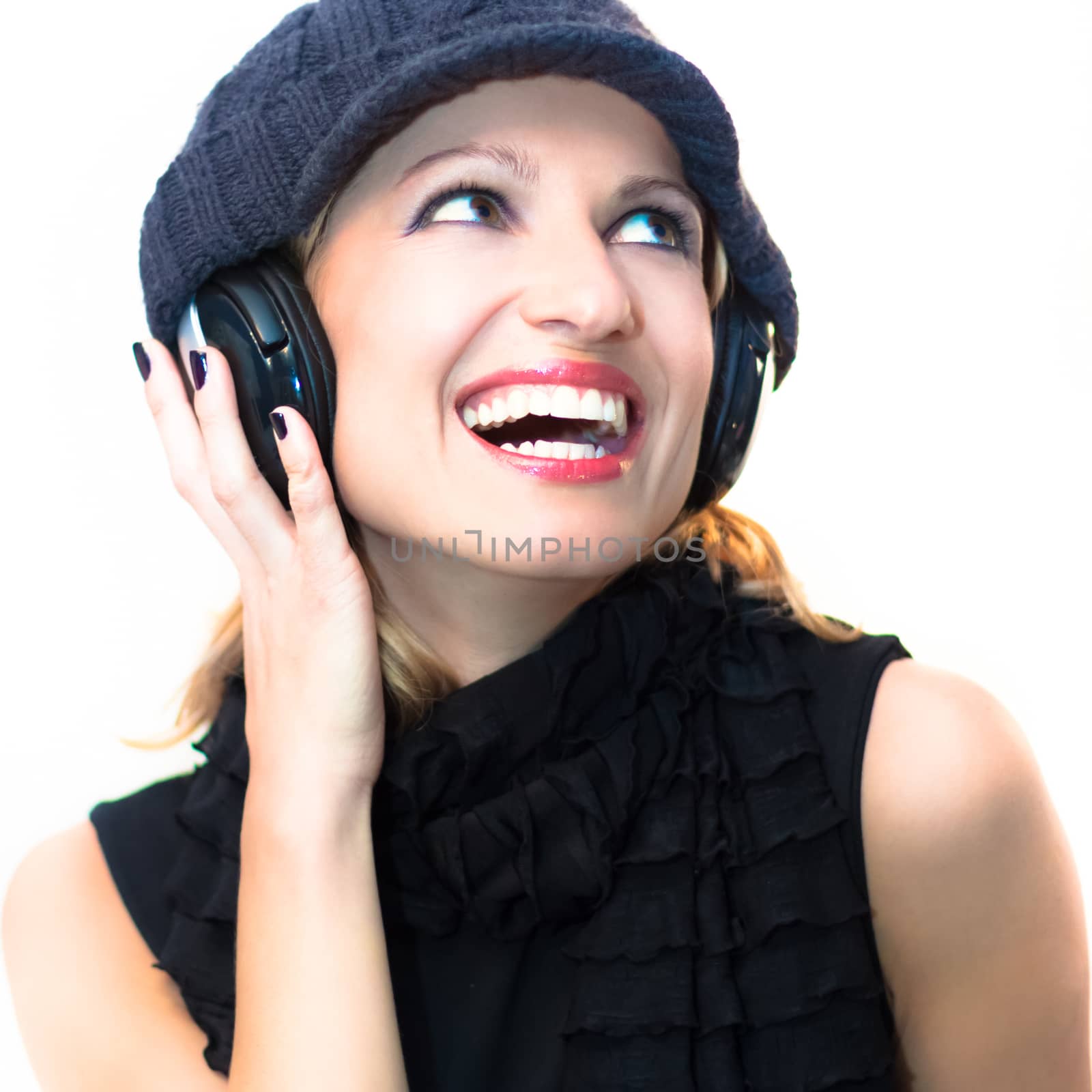 Blonde caucasian girl listening to the music with a pair of headphones