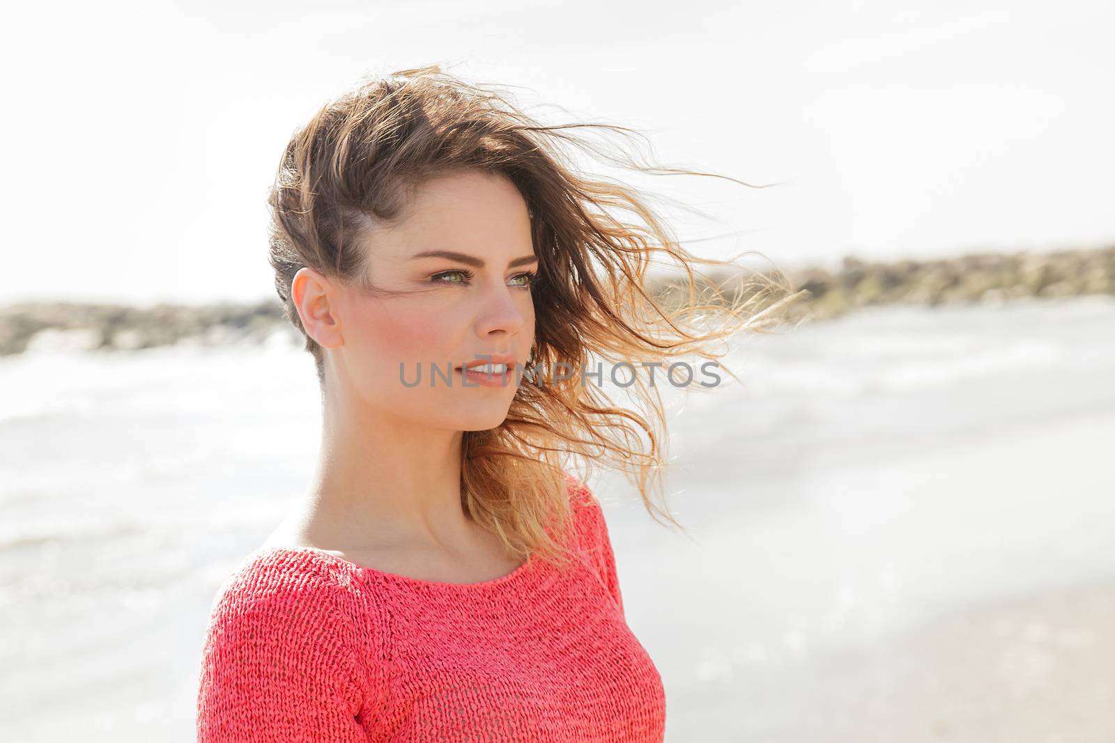 Beautiful young girl looking aside on the beach