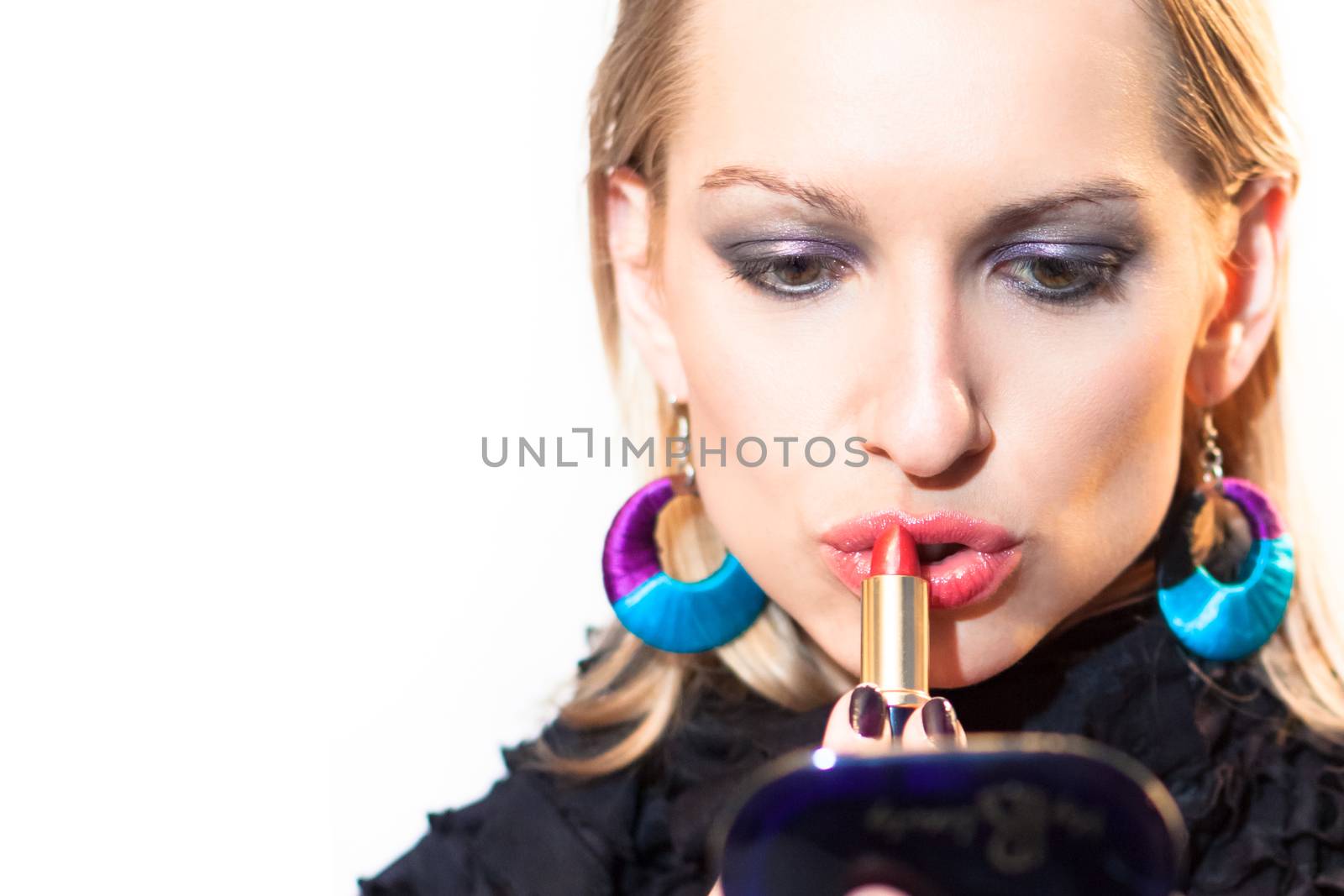 Young beautiful woman applying fashionable colorful party make-up.