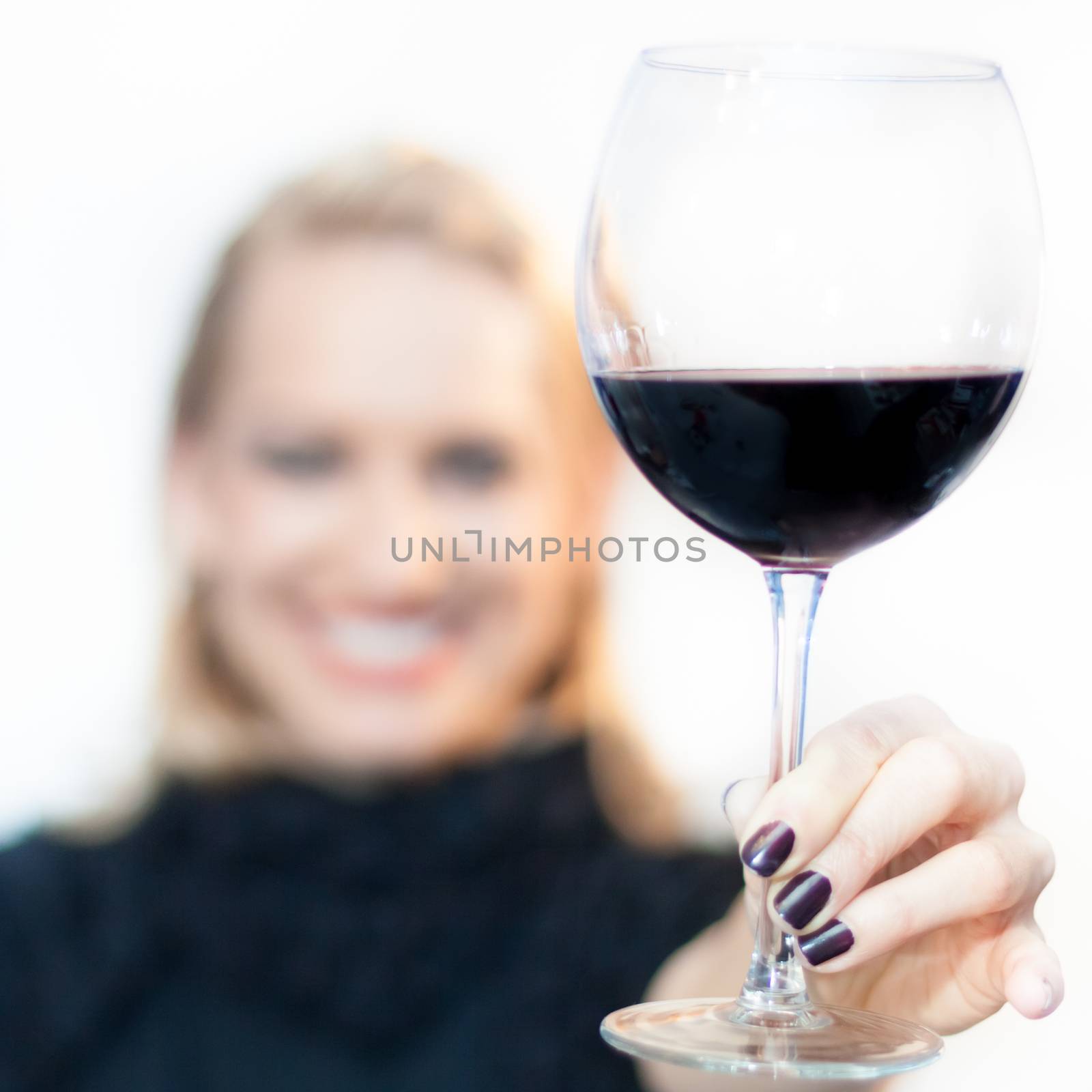 Business woman toasting with a glass of red wine.