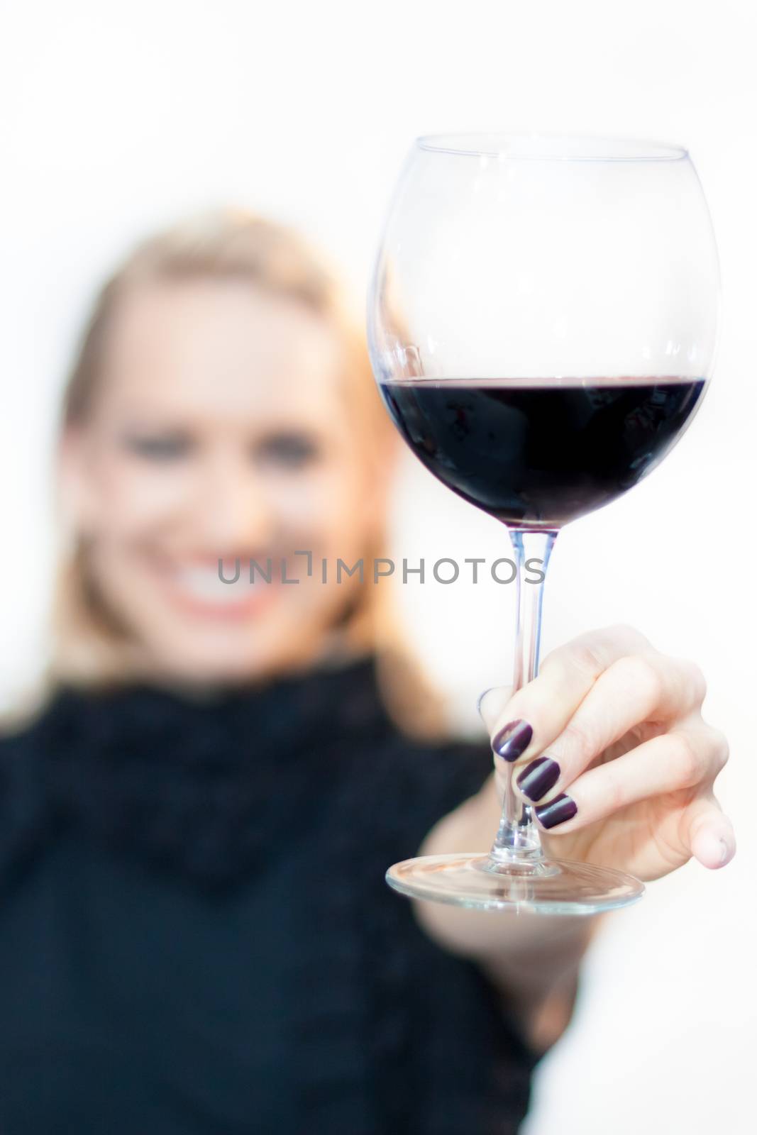 Business woman toasting with a glass of red wine.