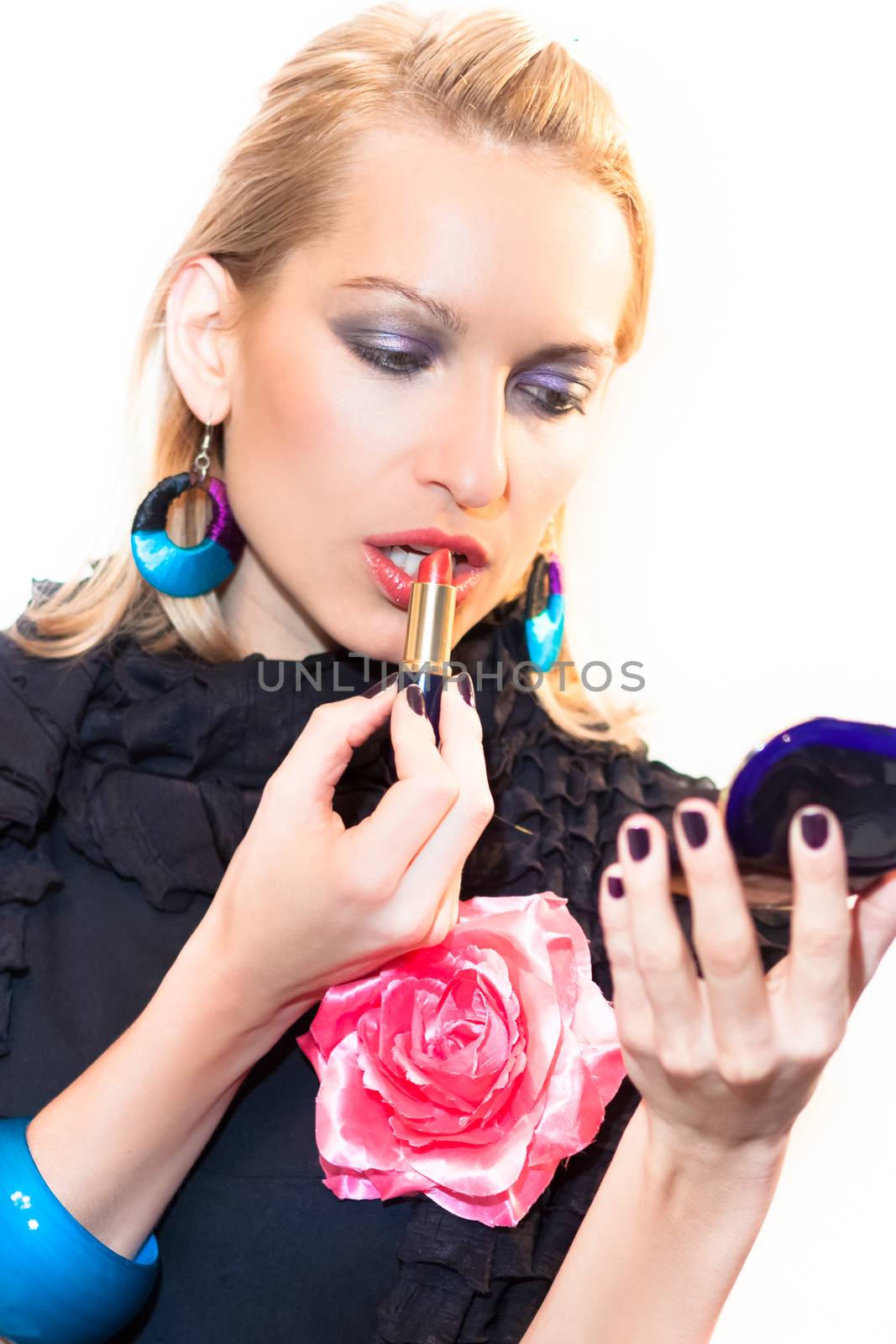 Young beautiful woman applying fashionable colorful party make-up.