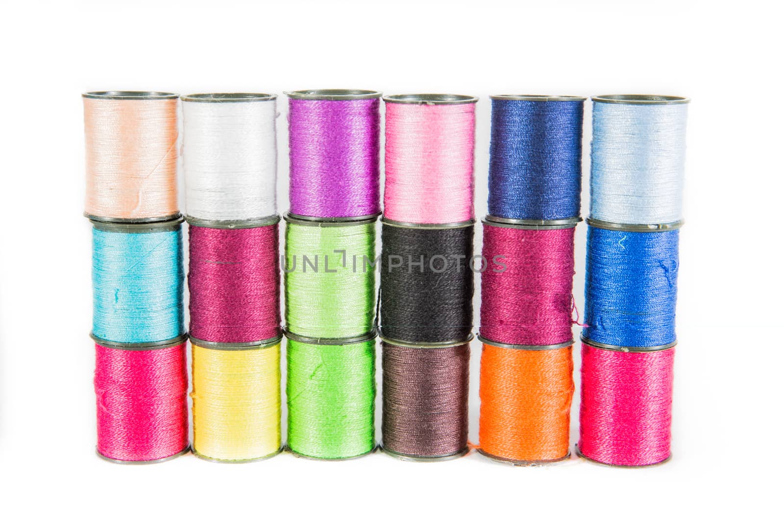 Colorful sewing threads on white.