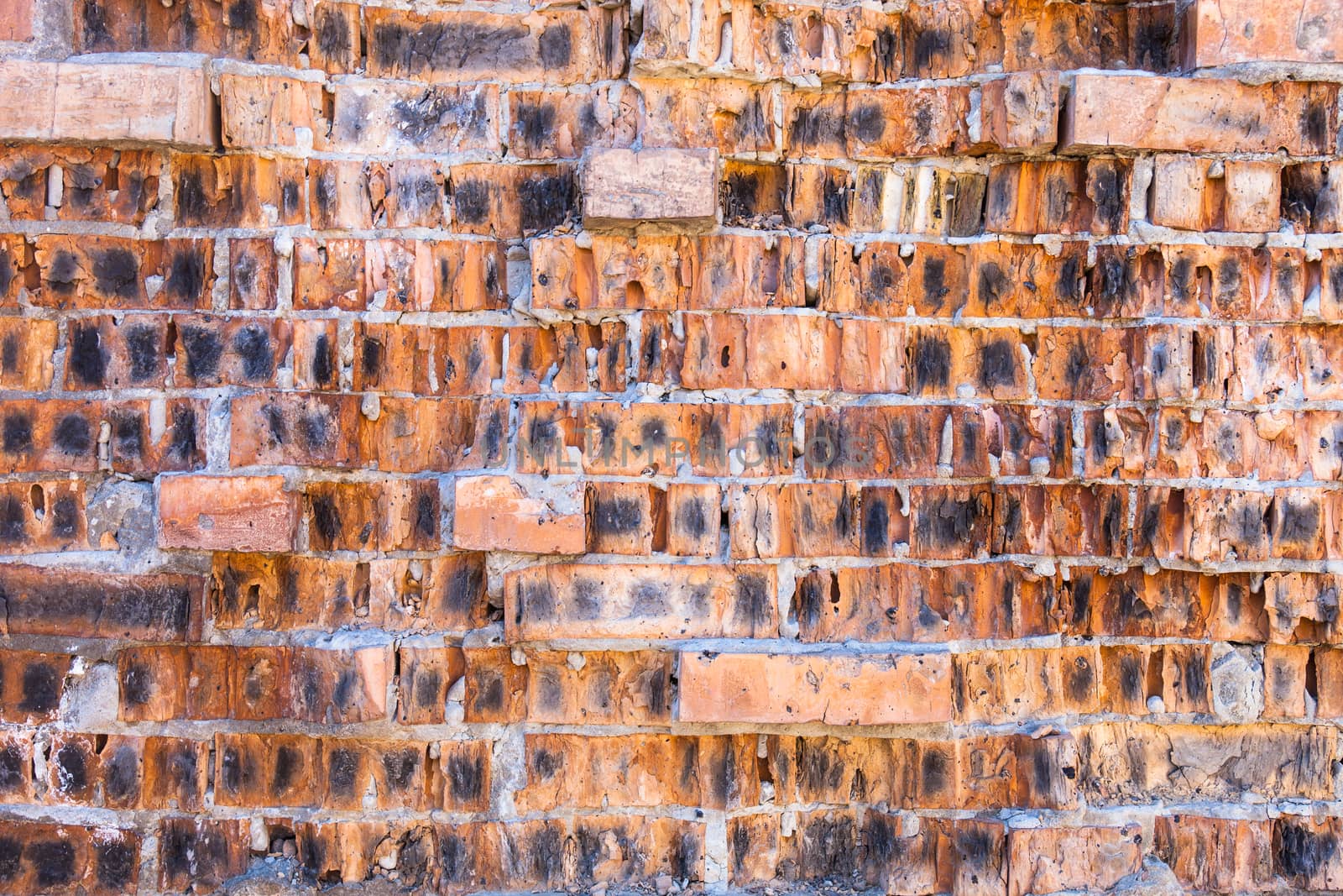 Red brick wall with split defective bricks