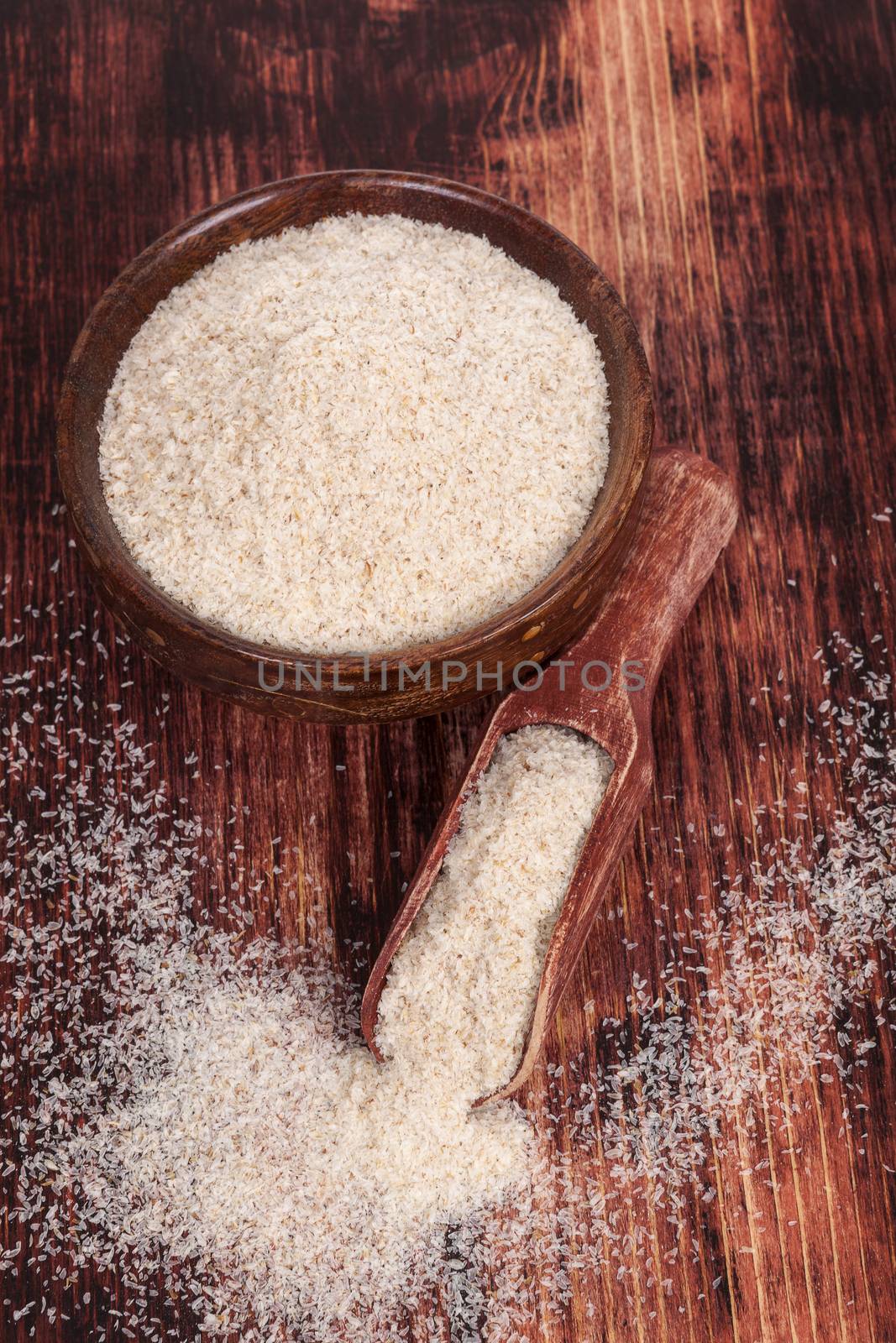 Ispaghula psyllium. Detox, body cleansing dietary supplement. Psyllium powder in wooden bowl and on wooden scoop on wooden background. Healthy diet.