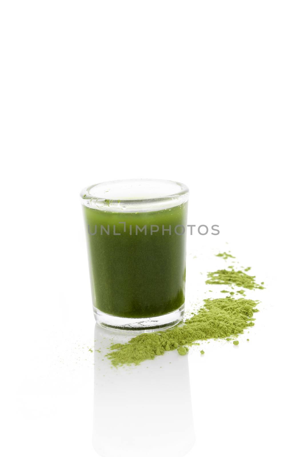 Detox. Green food supplement. Ground wheatgrass powder with green juice in glass isolated on white background.