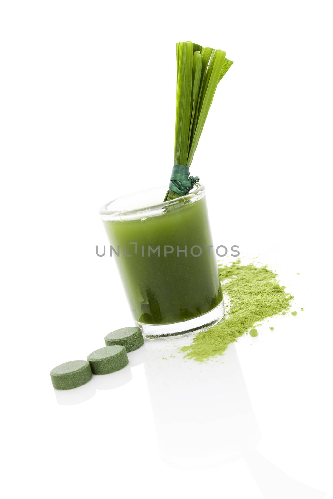 Green food supplement. Spirulina, chlorella and wheatgrass. Green juice, green pills, wheatgrass blades and ground powder isolated on white background. Healthy lifestyle.