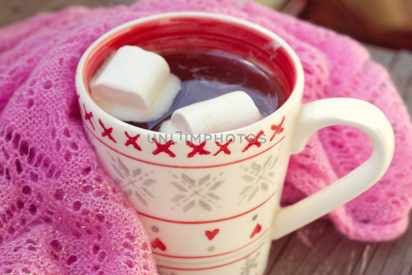 A rich cup of hot chocolate wrapped in a cozy winter scarf