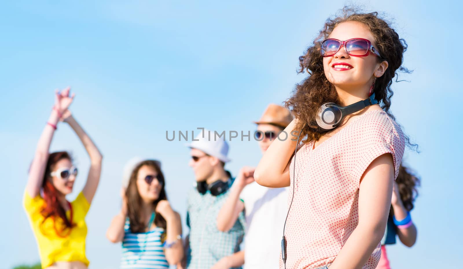 young woman with headphones on a background of blue sky and funny friends