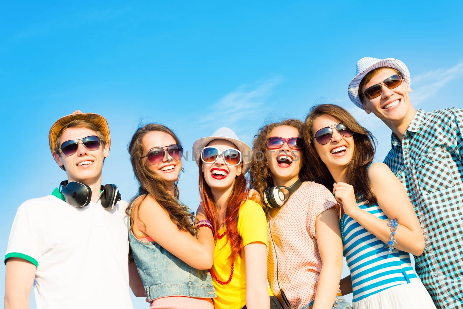 group of young people wearing sunglasses and hats hugging and standing in a row, spending time with friends