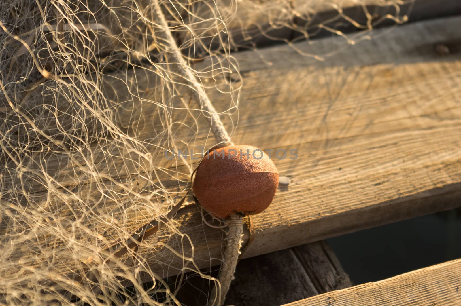 Fishing net with floats resting on wooden jetty