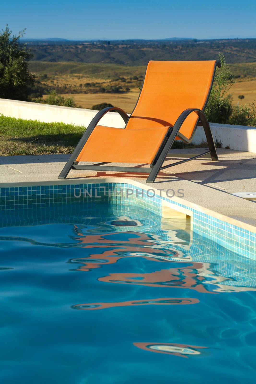 Chaise lounge around swimming pool at a sunny day