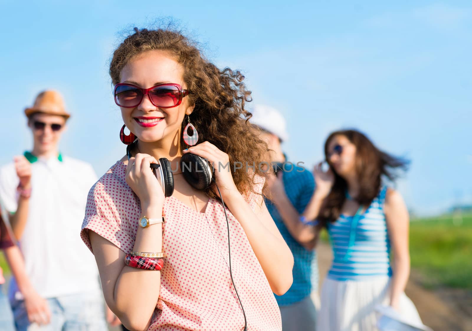 young woman with headphones on a background of blue sky and funny friends