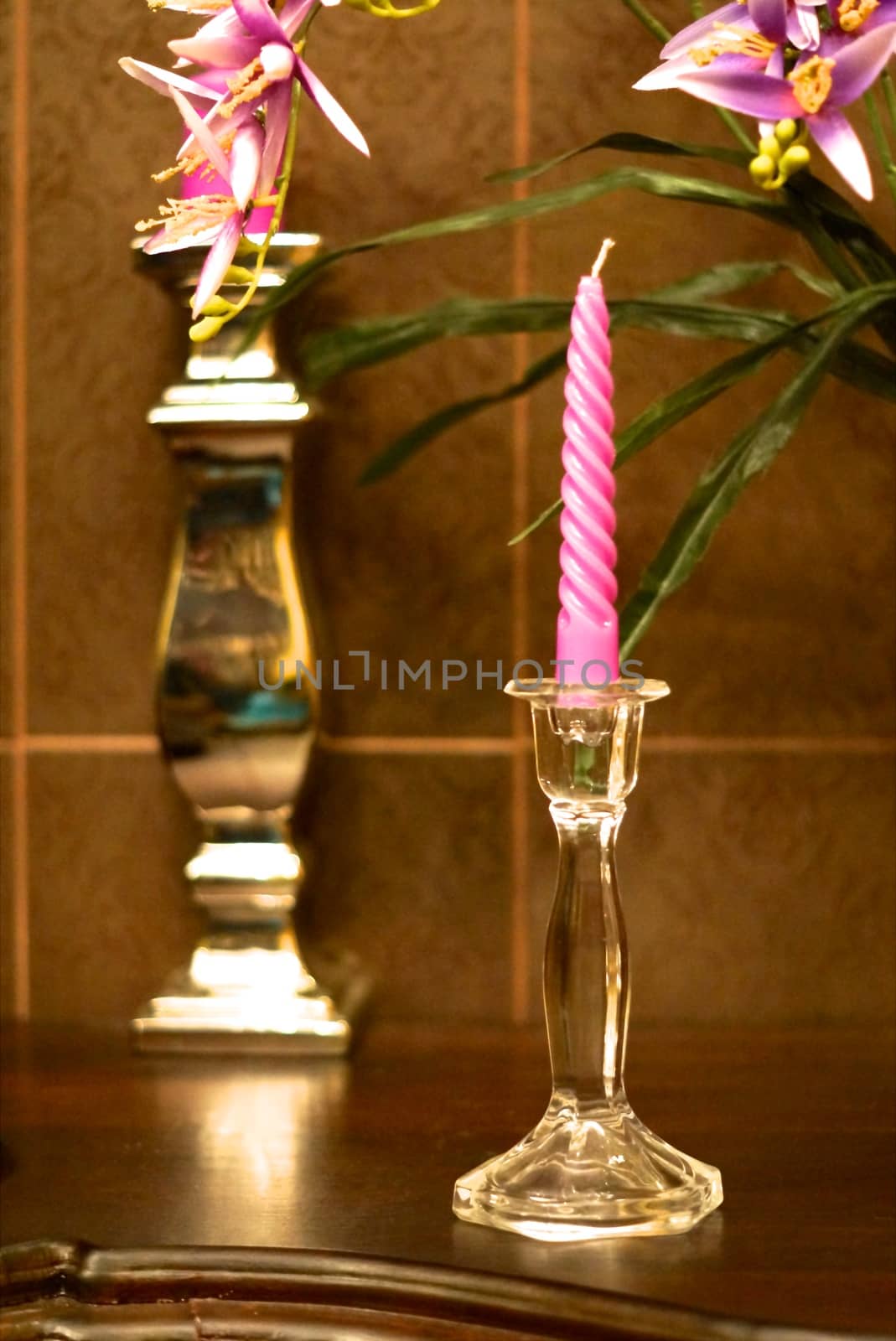 glass candle stick and violet candle on wood deck