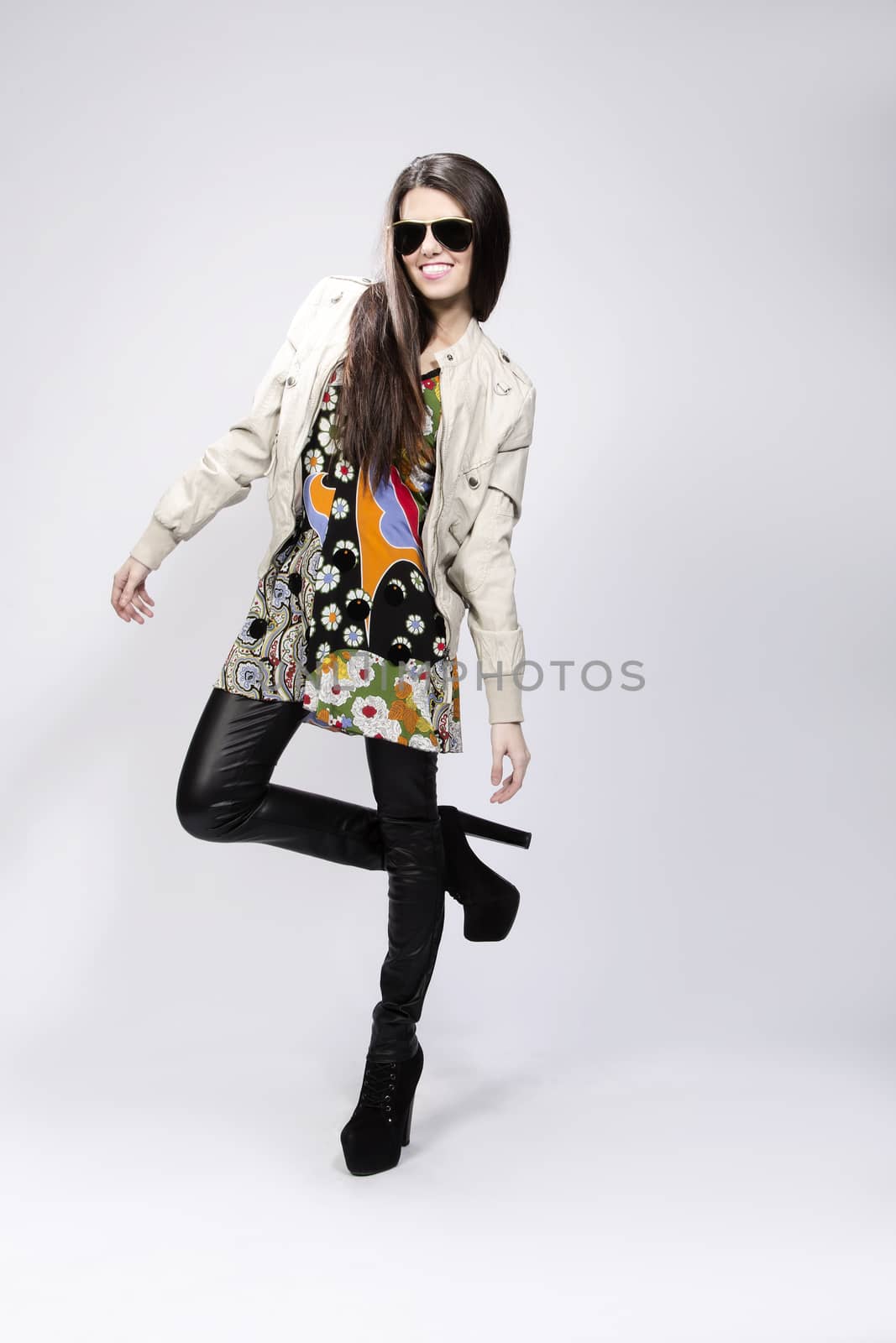 Happy young brunette woman with sun glasses against white background, Fashion portrait