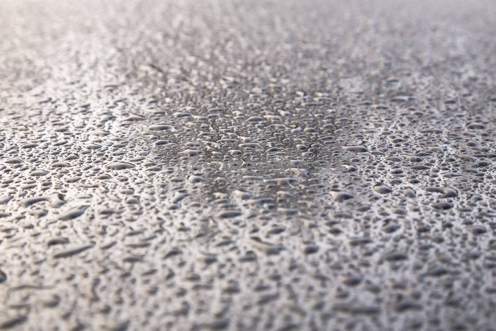 Water drops on metal background with reflection blurred on the edges
