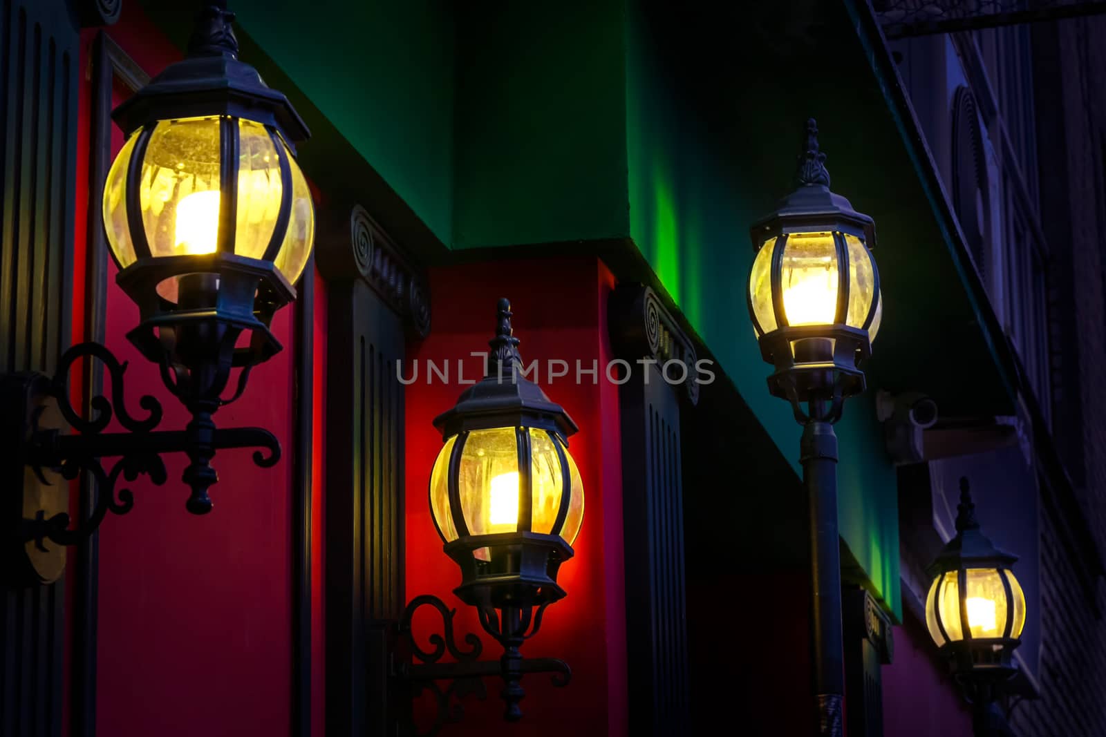 Vintage street lamps at the evening on red wall background