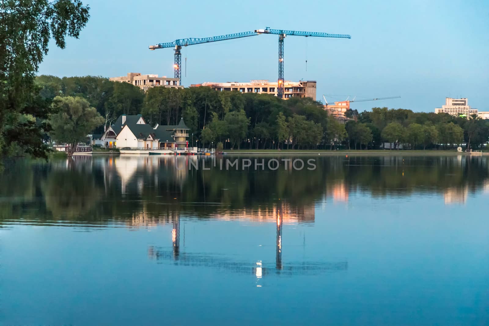 Construction crane on city scene with reflection on water