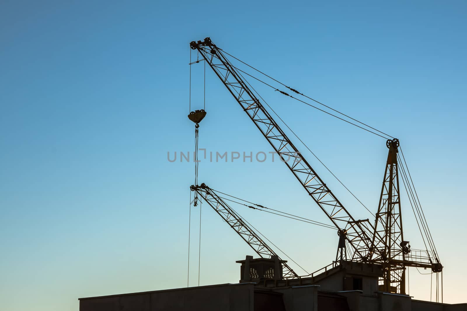 Construction crane on clear blue sky background