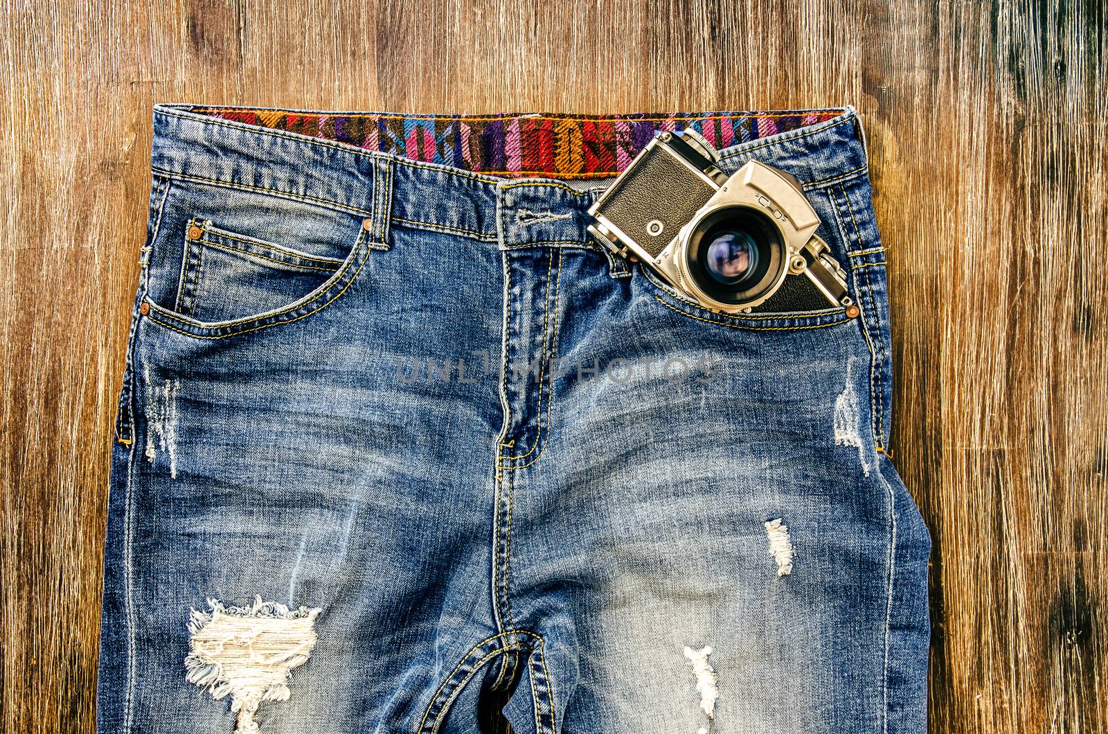 Detail of vintage jeans with classic camera in the pocket