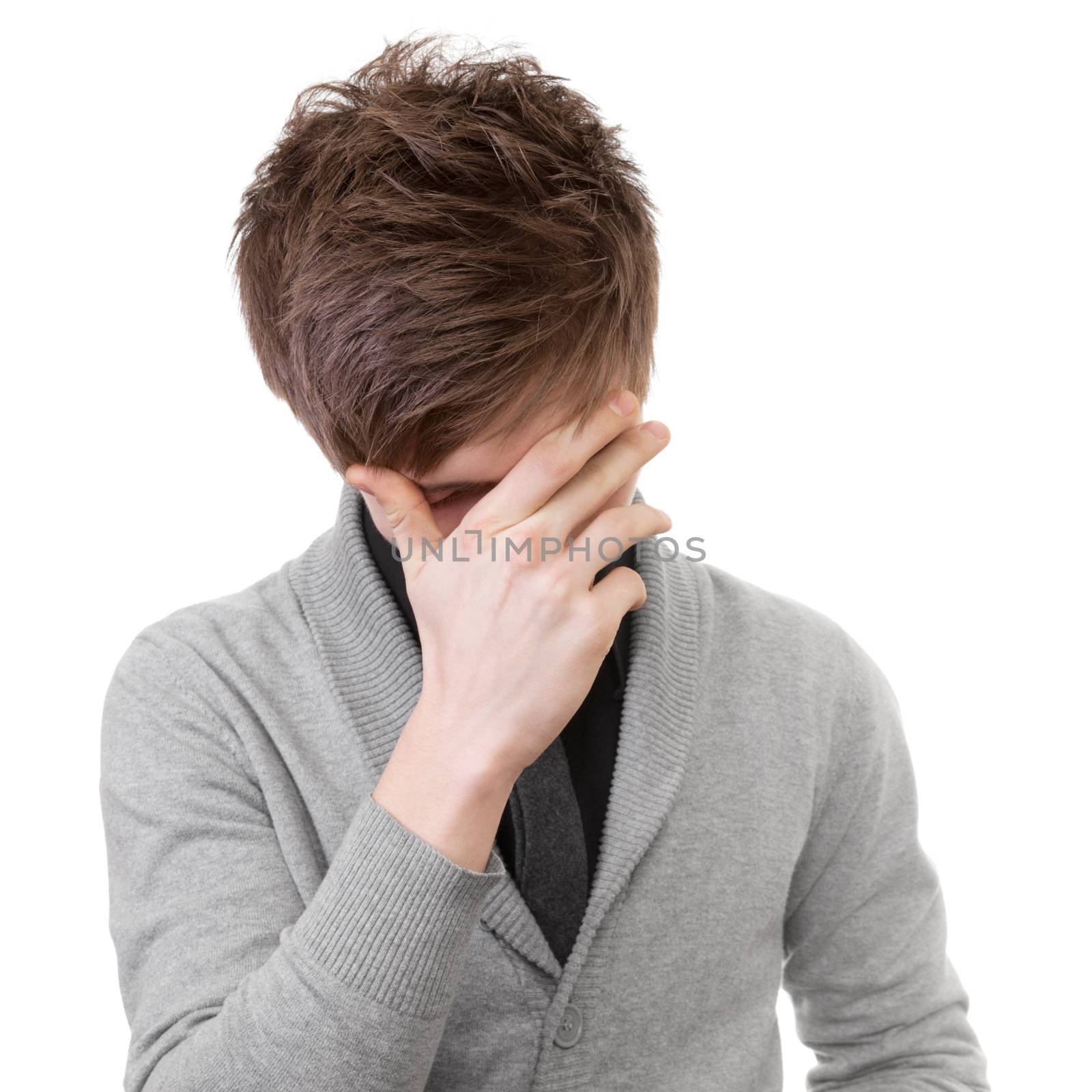 Sad young man covered his face with his hand. Isolation on white