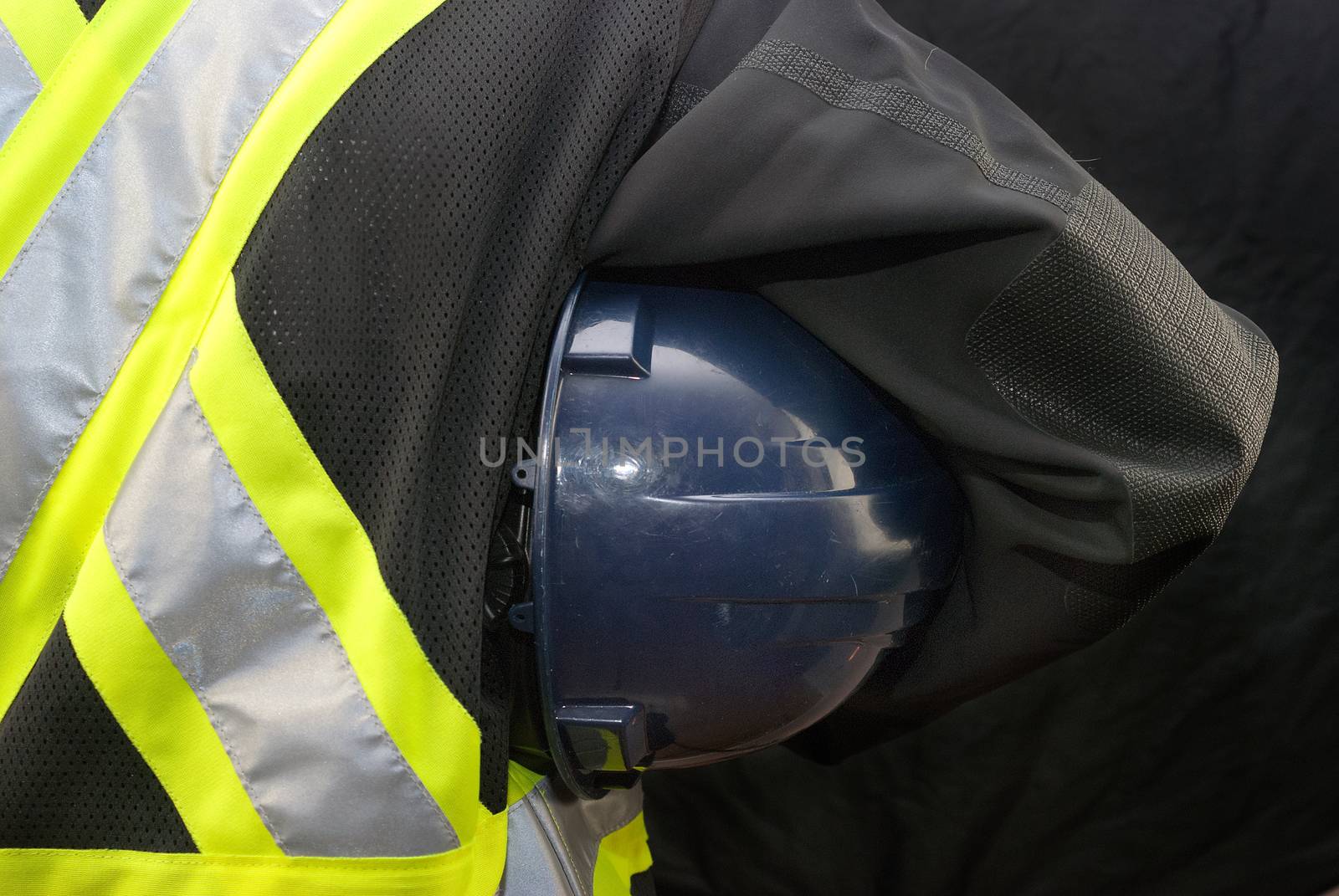 Close-up of a construction worker holding his hardhat under his arm.
