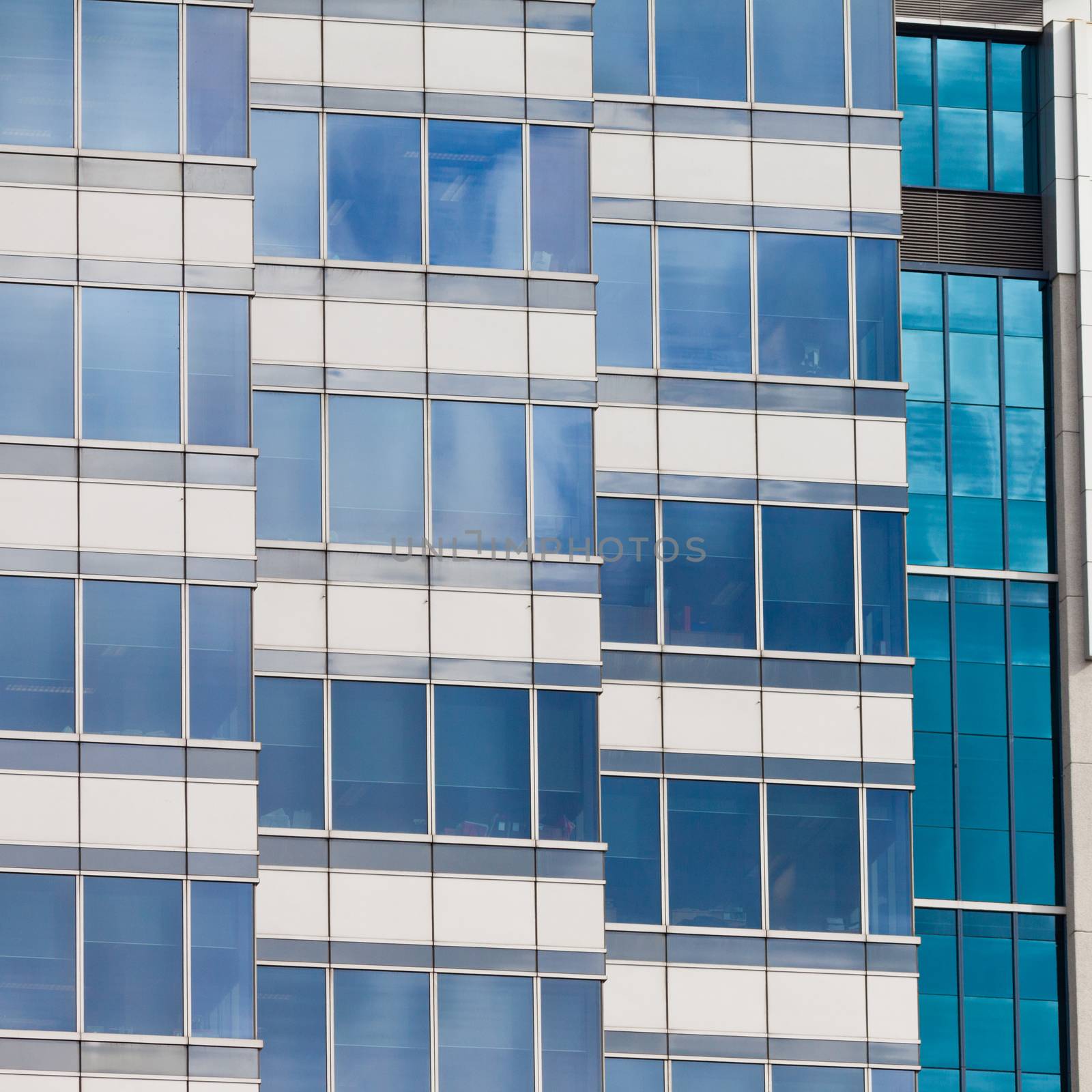 Background pattern of blue window reflections in a modern coporate office building facade