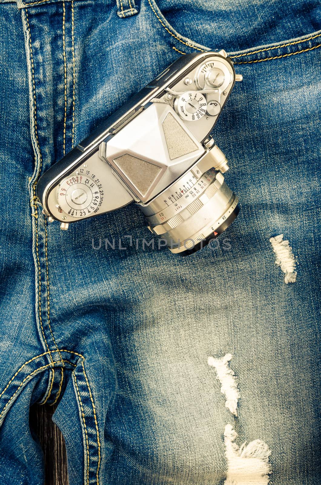 Close-up detail of vintage jeans with classic camera by martinm303