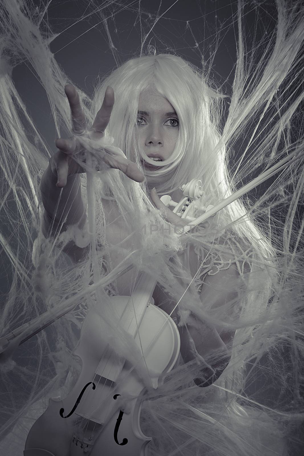 Music, beautiful woman trapped in a spider web with a white violin, lace dress