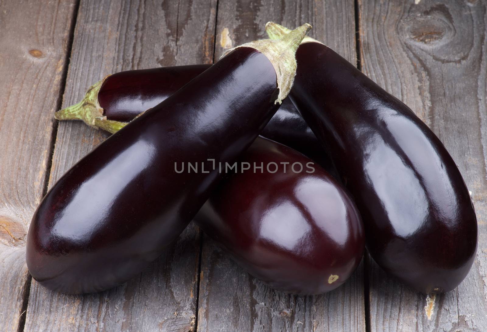 Heap of Fresh Ripe Eggplants isolated on Rustic Wooden background