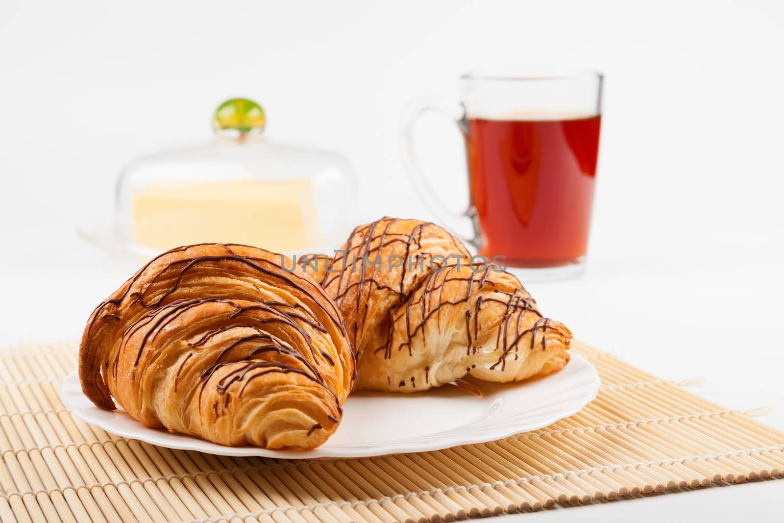 Two croissant and a cup of black tea. Shallow depth of field