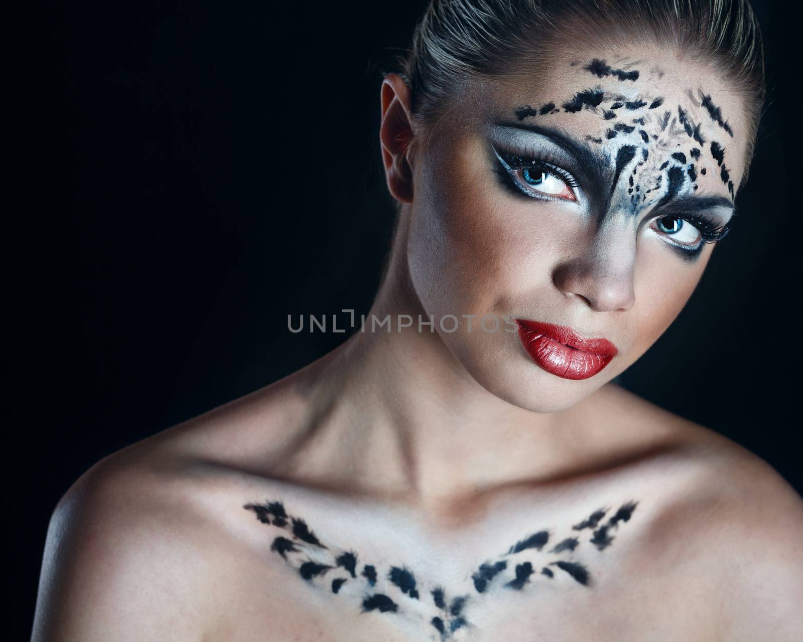 Attractive young girl with make-up snow leopard close-up portrait