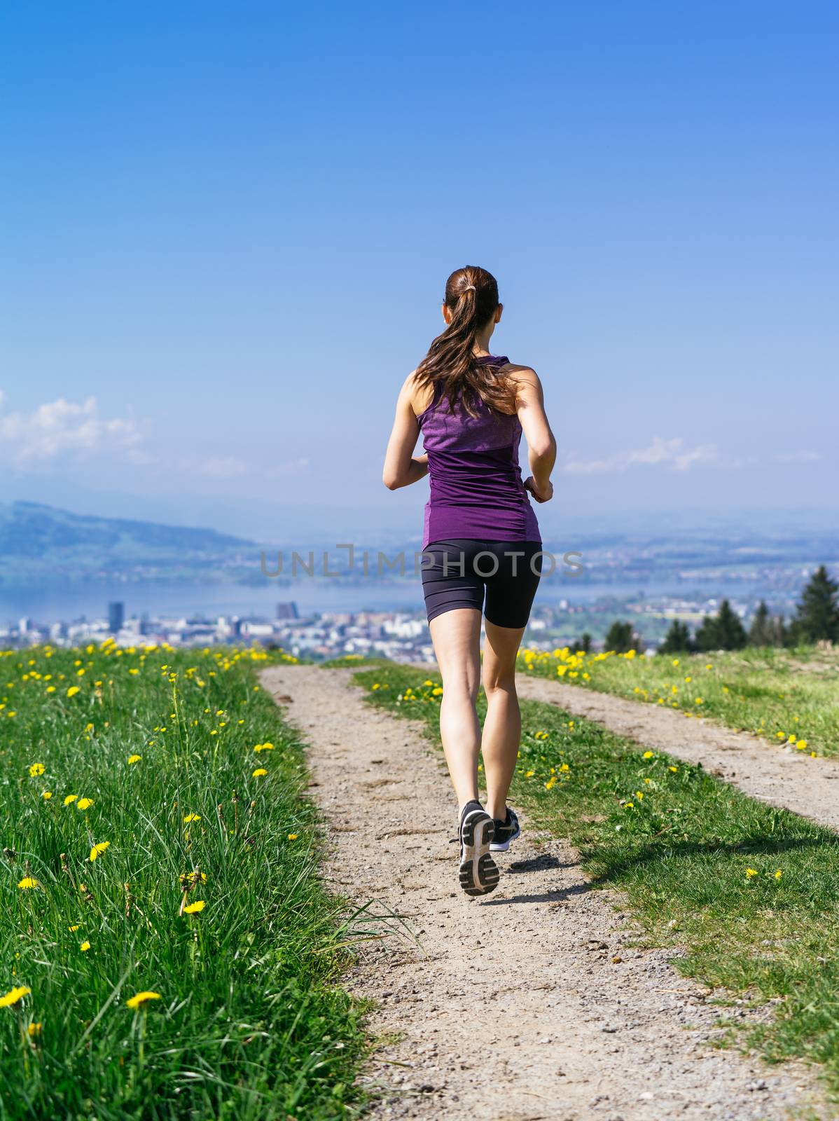 Young fit woman running down gravel road by sumners